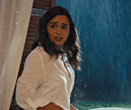 Woman in White Shirt by Window in Rain