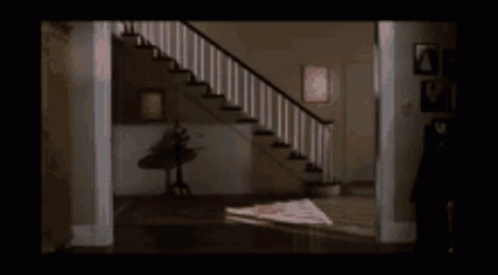 Woman In White Shirt In Hallway By Stairs GIF