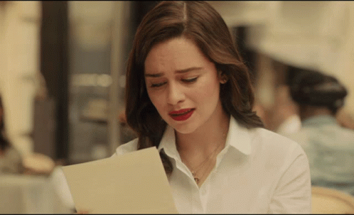 Woman in White Shirt Looking at Paper