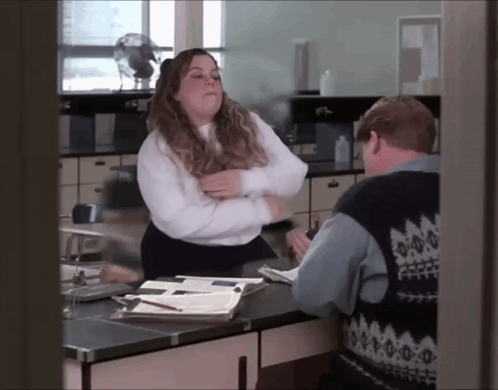 Woman In White Shirt Next To Man In Blue Vest GIF
