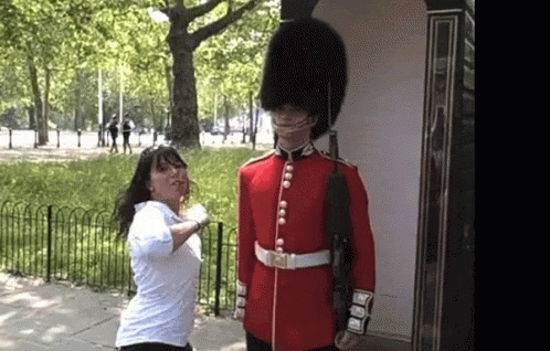 Woman in White Shirt Next to Man in Red Uniform