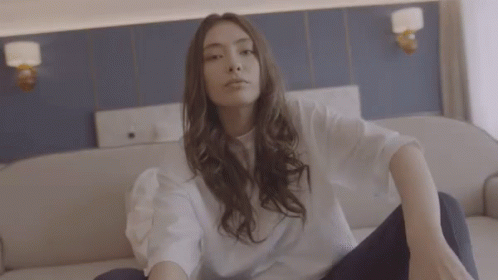 Woman in White Shirt Sitting Crossed Legs