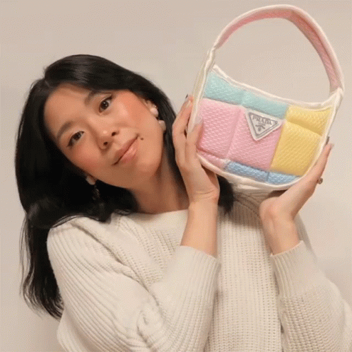 Woman in White Sweater Holding Prada Purse