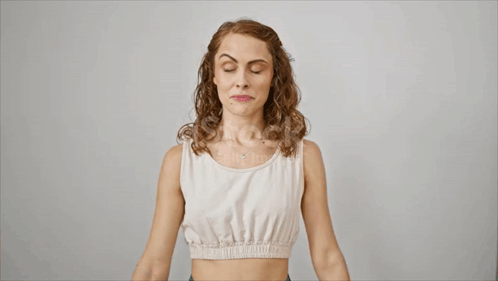 Woman in White Tank Top Flexing Biceps
