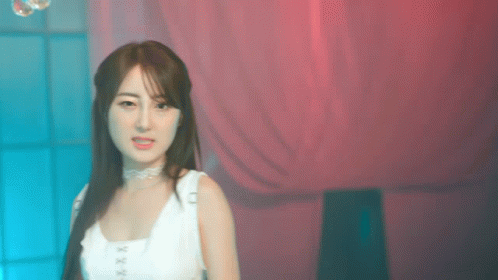 Woman in White Tank Top in Front of Pink Curtain
