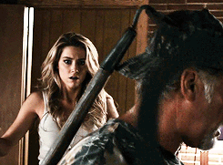 Woman In White Tank Top Next To Man In Camouflage Hat GIF