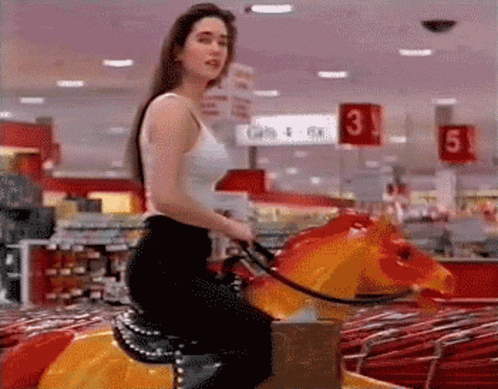 Woman in White Tank Top Riding Carousel Horse