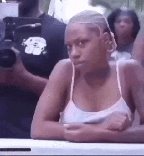Woman In White Tank Top Sitting With Arms Crossed GIF