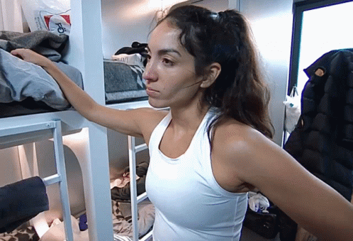 Woman In White Tank Top Standing In Room GIF