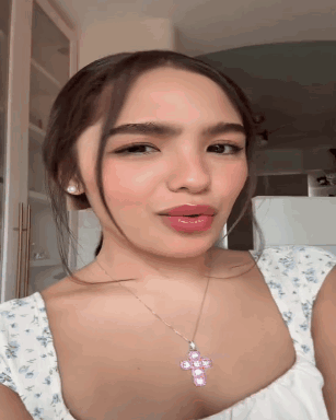 Woman in White Top and Pink Cross Necklace