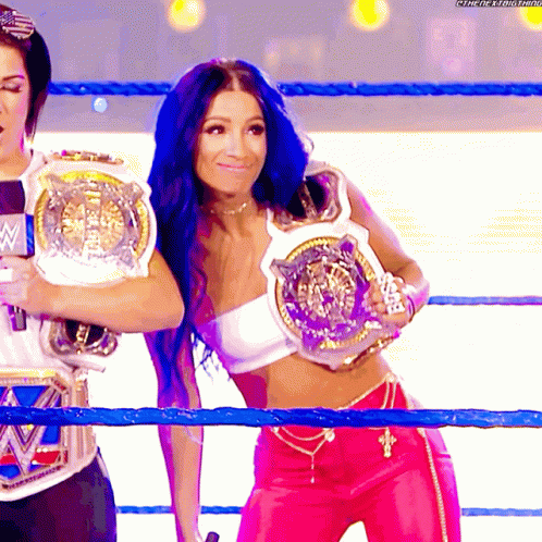 Woman In White Top And Pink Pants Holding WWE Belt GIF