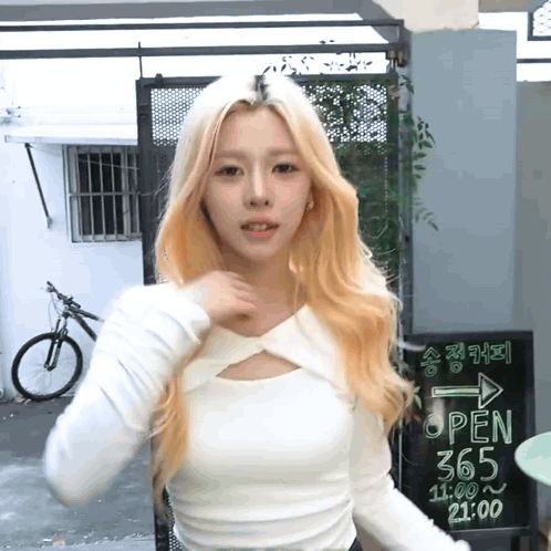 Woman In White Top In Front Of Open 365 Sign GIF