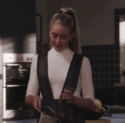 Woman in White Turtleneck and Black Overalls in Kitchen