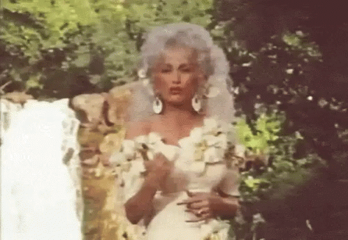 Woman In White Wedding Dress In Front Of Waterfall GIF