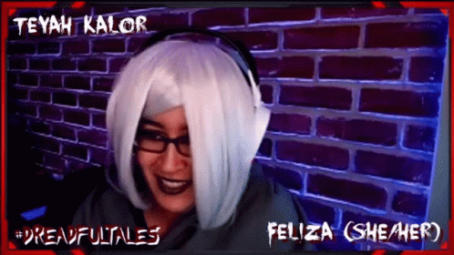 Woman in White Wig and Headphones Smiling in Front of Teyah Kalor Brick Wall