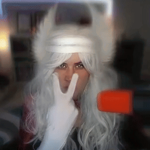 Woman in White Wig and White Gloves Giving Peace Sign