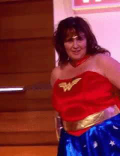 Woman In Wonder Woman Costume Standing In Front Of Door GIF