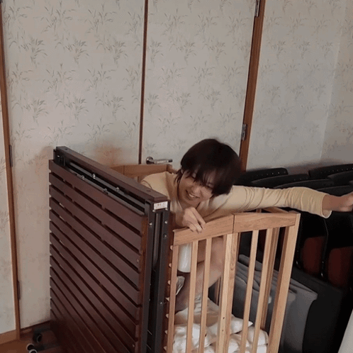Woman in Wooden Crib Arms Outstretched 'A