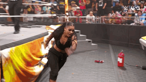 Woman in Wrestling Ring With Fire Extinguisher
