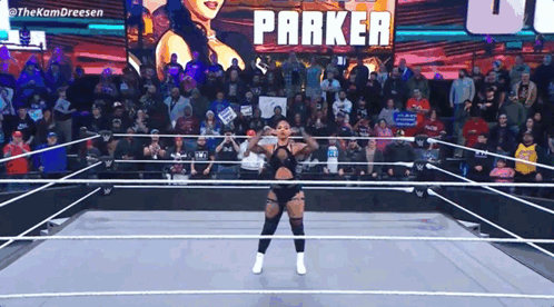Woman in Wrestling Ring With Parker on Screen