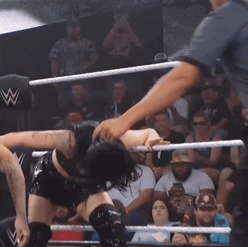 Woman in Wrestling Ring with Referee and Crowd