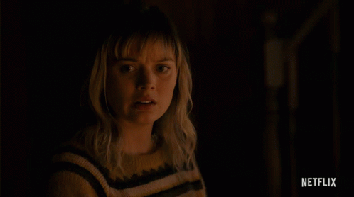 Woman In Yellow Black Striped Sweater With Netflix Logo Above GIF