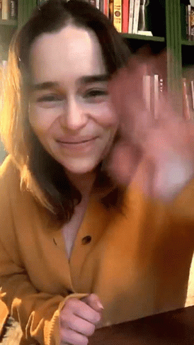 Woman in Yellow Cardigan Smiling and Waving