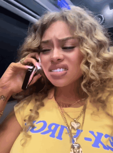 Woman In Yellow CK T-Shirt Talking On Phone GIF