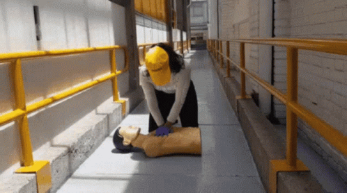 Woman in Yellow Hat Giving Heart Massage to Mannequin