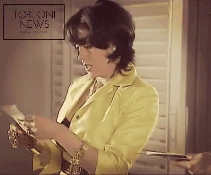 Woman In Yellow Jacket Reads Torloni News GIF