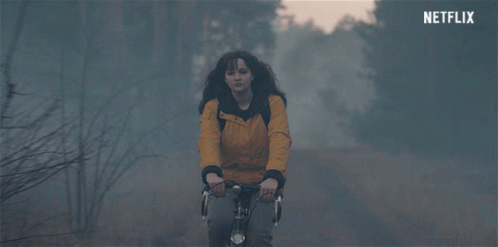 Woman in Yellow Jacket Riding Bike With Netflix Logo