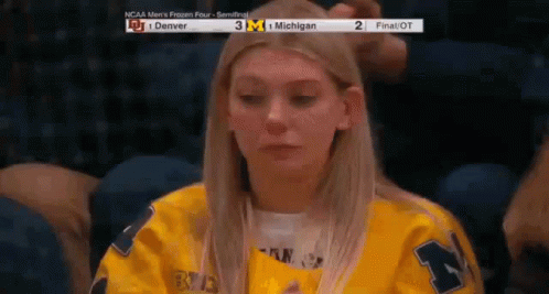 Woman in Yellow Jersey Watching Game at Stadium