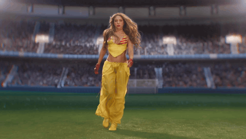 Woman in Yellow Outfit Walking on Soccer Field