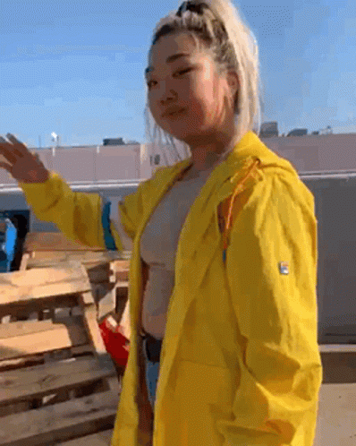 Woman in Yellow Raincoat by Wooden Pallet