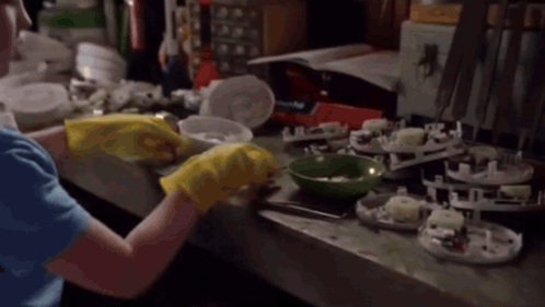 Woman in Yellow Rubber Gloves Cleaning Counter