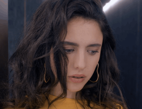 Woman in Yellow Shirt and Gold Hoop Earrings Looking Down
