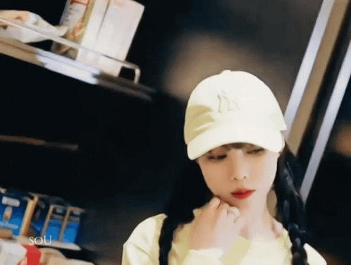 Woman in Yellow Shirt and White Hat with Letter N