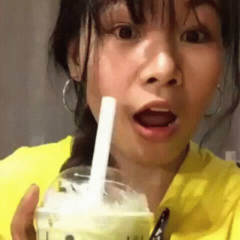 Woman In Yellow Shirt Drinking With Straw GIF