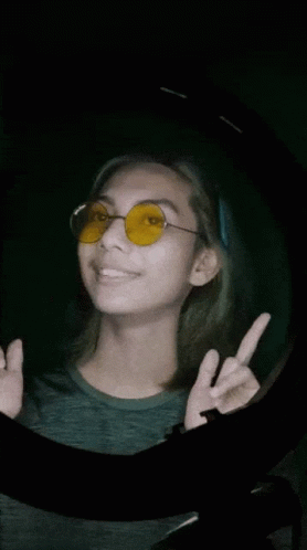 Woman In Yellow Sunglasses Giving Peace Sign GIF