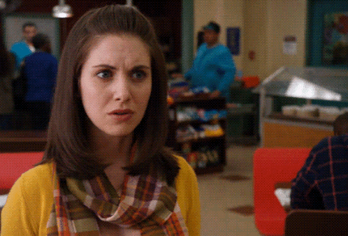 Woman in Yellow Sweater and Plaid Scarf Surprised
