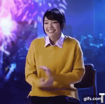 Woman in Yellow Sweater Smiling at Fireworks