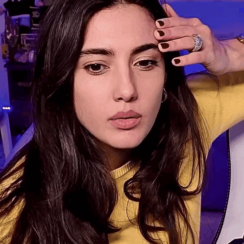 Woman In Yellow Sweater Touching Forehead GIF