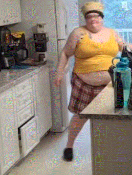 Woman in Yellow Tank Top and Plaid Skirt in Kitchen