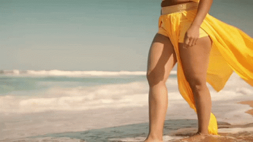Woman in Yellow Top and Shorts on Beach