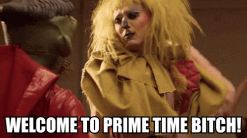 Woman In Yellow Wig Next To Man Saying Welcome To Prime Time Bitch GIF