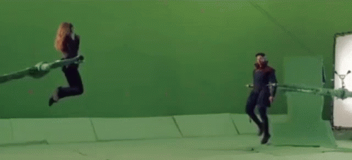 Woman Jumping in Front of Green Screen With Clapper Board