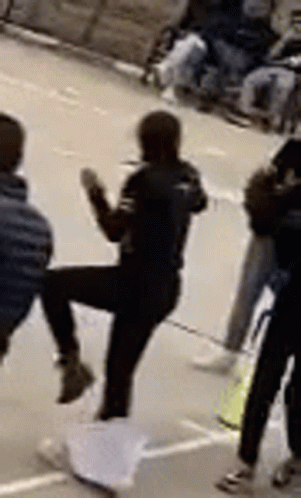 Woman Kicking Man In Front Of Group GIF