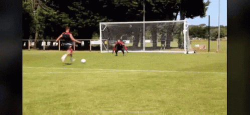 Woman Kicking Soccer Ball into Goal with Goalie