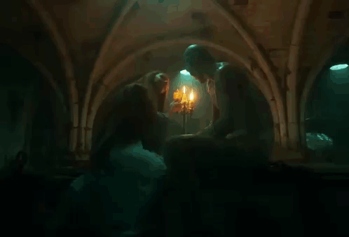 Woman Kissing Man In Front Of Candles GIF