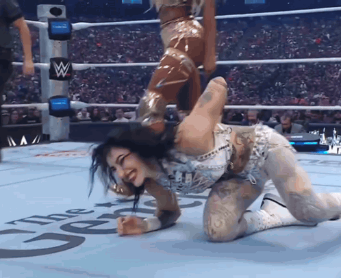 Woman Kneeling in Wrestling Ring With Letter W